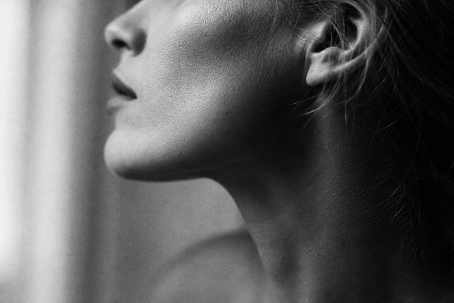 Portrait of a composed woman with natural, healthy skin in warm light